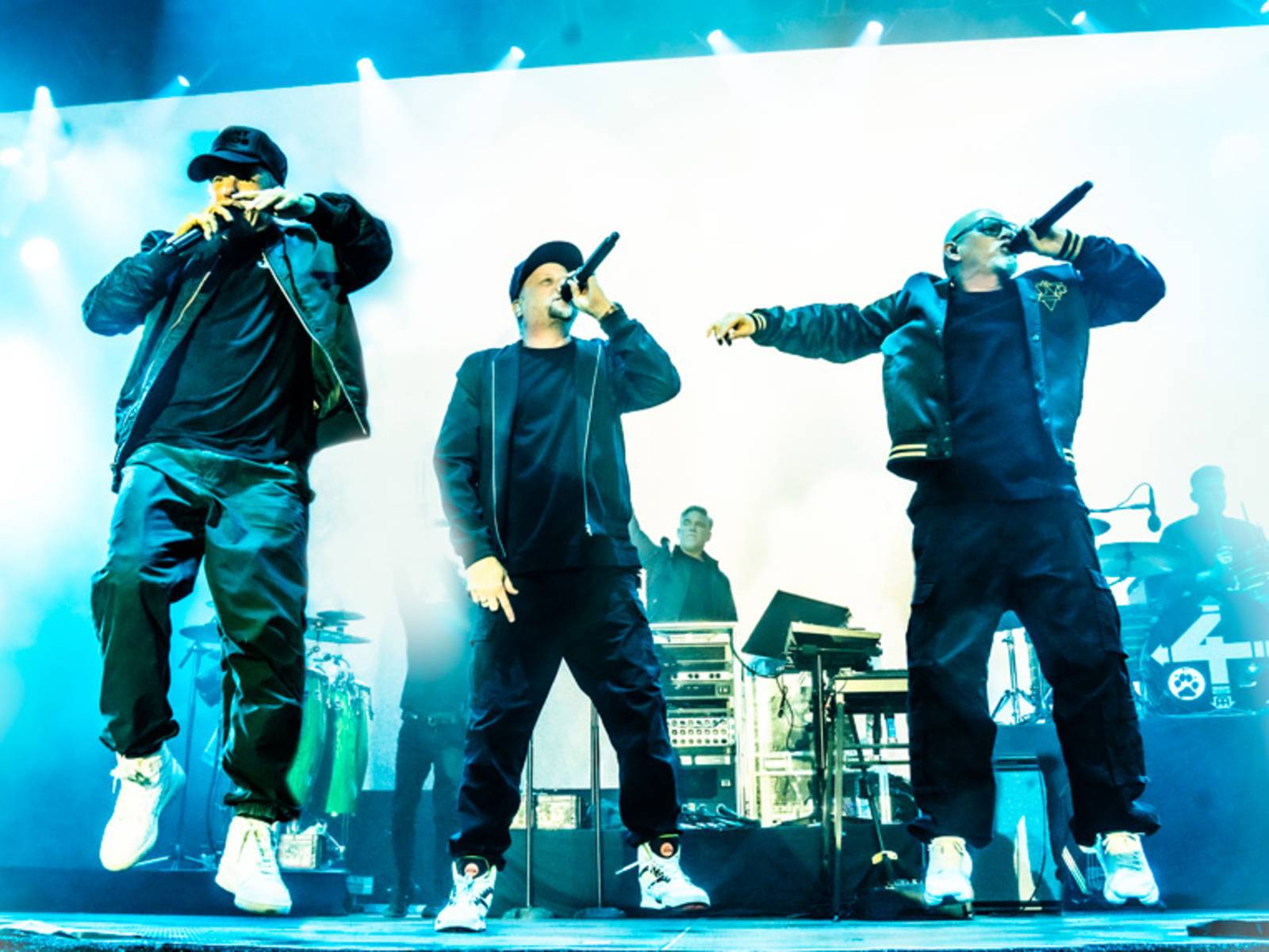 Three hip-hop artists are performing on stage