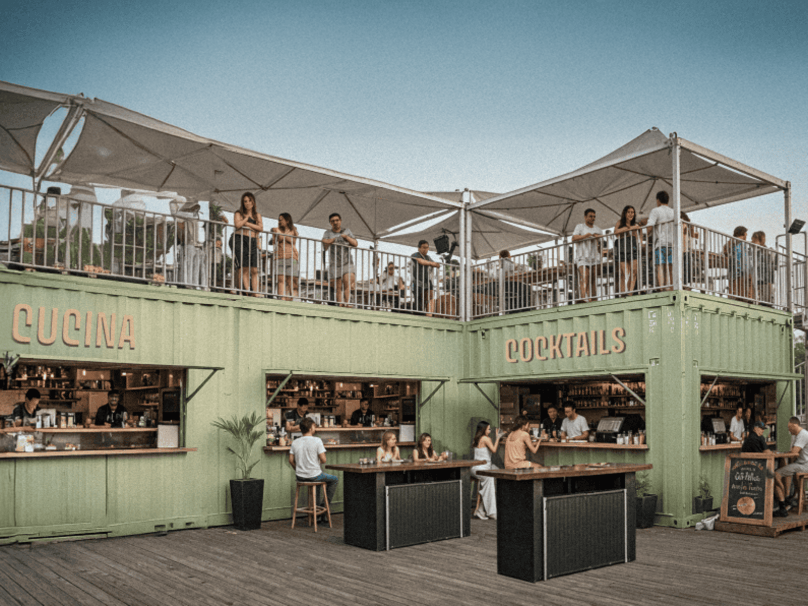 Bar mit Terrasse, Menschen genießen Drinks und Essen in entspannter Sommeratmosphäre.