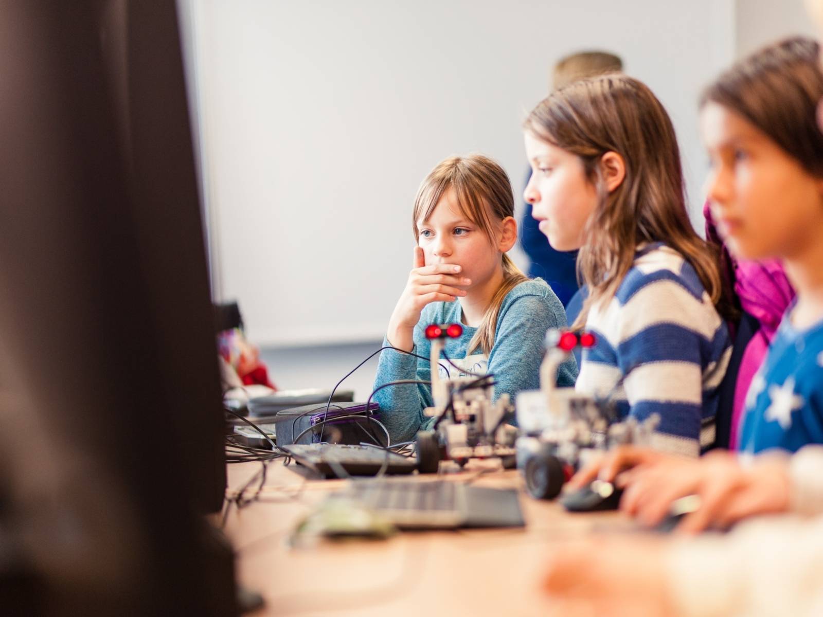 Tre studentesse sono sedute davanti al computer.