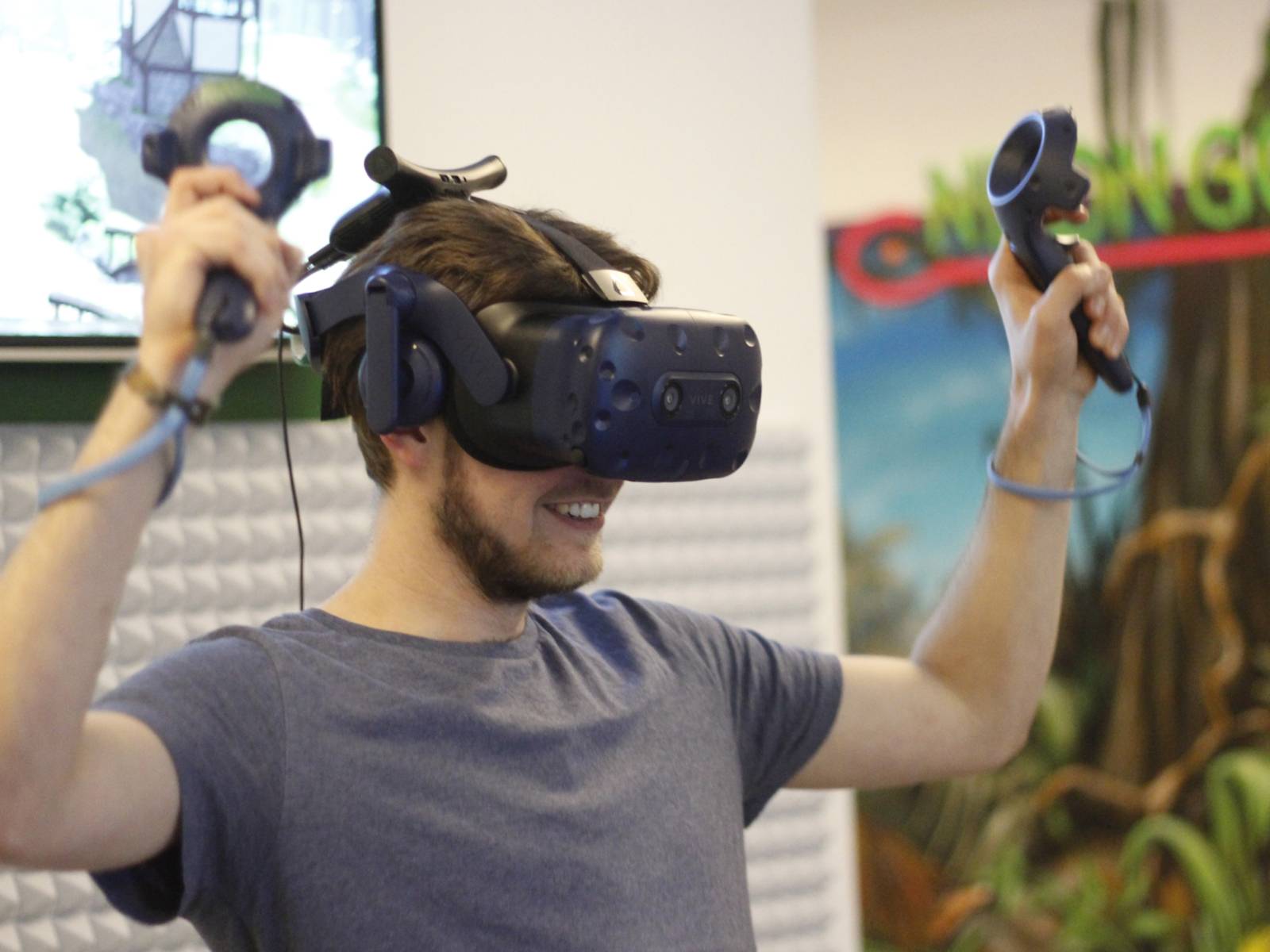 Jubelnder junger Mann mit technischer Apparatur auf dem Kopf