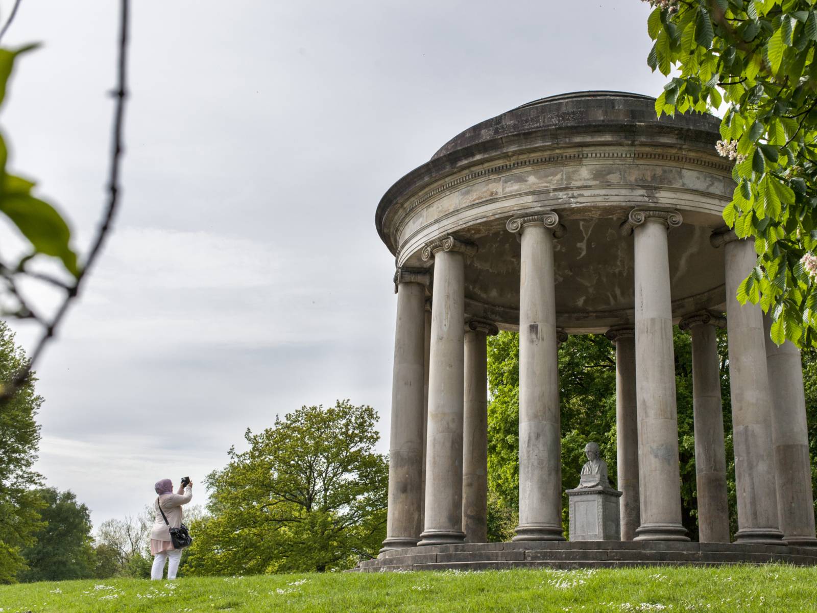 Kleiner Rundtempel in einer Parklandschaft.