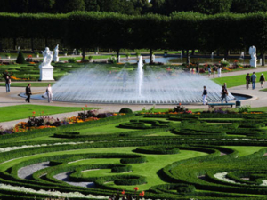 A fountain with a bell fountain surrounded by a park