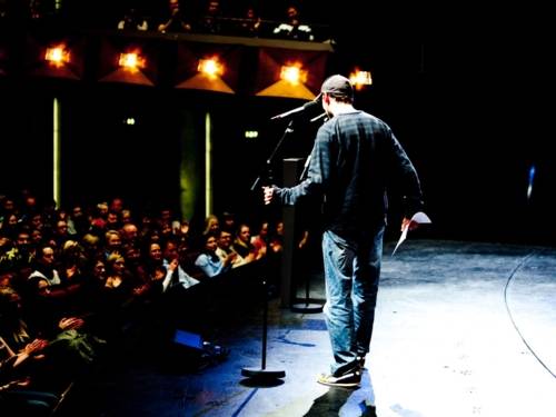 En el escenario se ve a un poeta de slam.