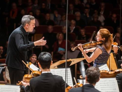 Dirigent und Geigerin mit Sinfonieorchester
