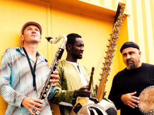 Drei Musiker stehen mit Instrumenten nebeneinander