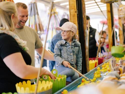 Eine kleine Familie am Stand für Entenangeln.