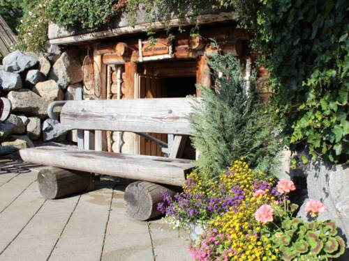 Eine Holzbank aus dicken Bohlen vor einem aus Bohlen gebauten Gebäude