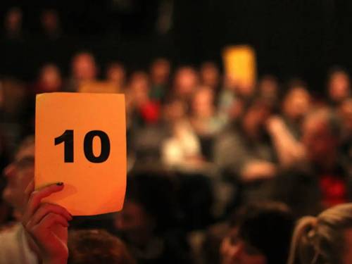 Entre el público, alguien levanta un papelito con el número 10