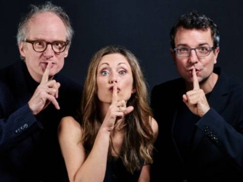 Eine Frau und zwei Männer halten ihre Zeigefinger vor den Mund.