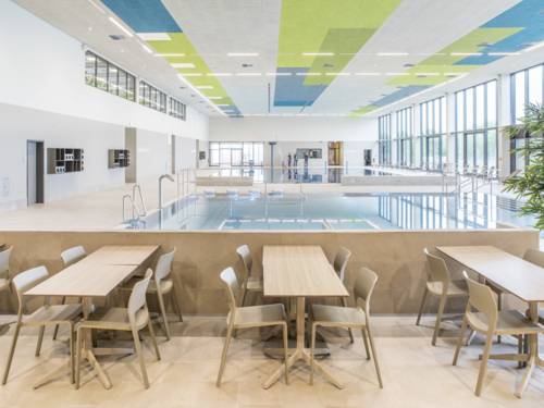 Mesas y sillas, con una piscina al fondo