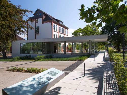 Blick von außen auf ein Gebäude mit gläsernem Foyer.