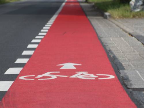 Straße mit einem rot markierten Fahrrad-Schutzstreifen
