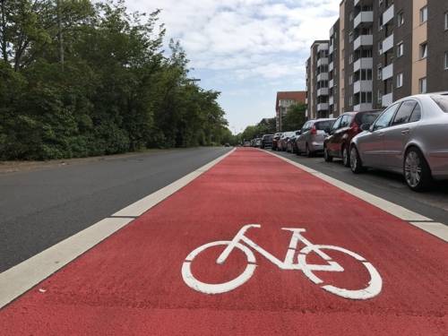 Eine Straße mit roter Markierung und einem weißen Fahrradpiktogramm