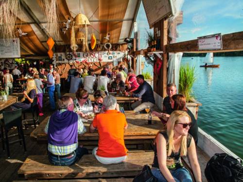 Sitzbänke eines aufgebauten Restaurants am See