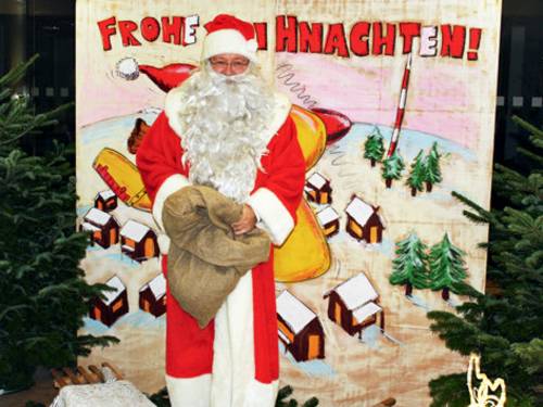 Eine Fotowand mit "Guckloch" für ein Gesicht, dass Sie zum Weihnachtsmann werden lässt.