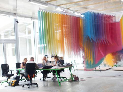 Ein Raum mit vier Menschen am Schreibtisch.