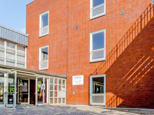 Am Eingang zur Grundschule An der Uhlandstraße sind Schultüten in Papierform an die Türen geklebt, die offen stehen. Die Schule ist in einem mehrstöckigen Backsteinbau untergebracht.