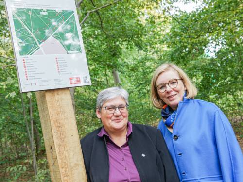 Zwei Frauen an einem Hinweisschild f&uuml;r einen Trimm-dich-Pfad