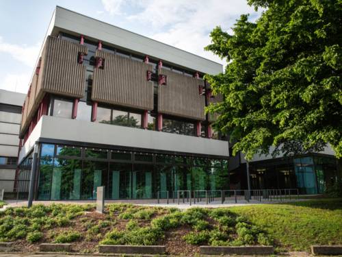 Gebäude hinter Bäumen.