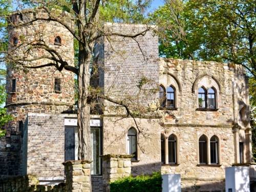 Burgähnliches Gebäude hinter Bäumen