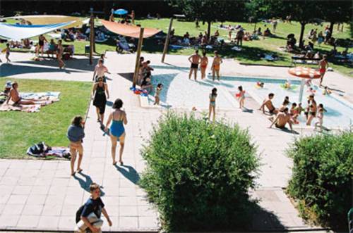 Blick auf das Kinderplantschbecken, Liegewiese mit vielen Besuchern im Hintergrund