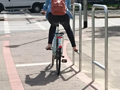 Une cycliste qui pose sa jambe sur une barre de pied.