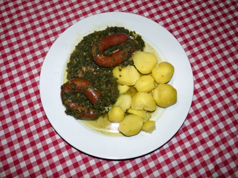 Teller mit Kartoffeln, Grünkohl und zwei Würsten