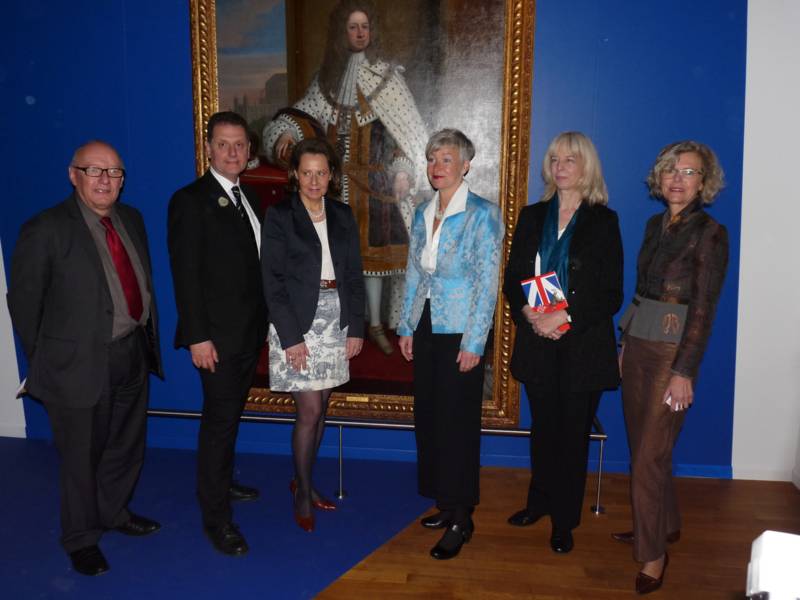Vier Frauen und zwei Männer vor einm Gemälde König Georg des Ersten.