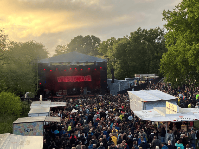 Eine Bühne bei Sonnenuntergang auf dem Faustgelände mit Publikum.