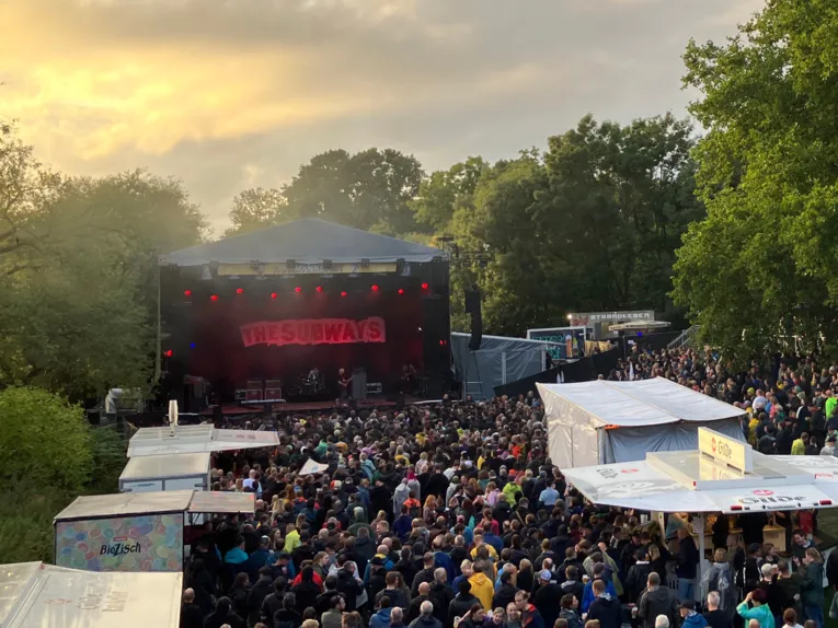 Eine Bühne bei Sonnenuntergang auf dem Faustgelände mit Publikum.