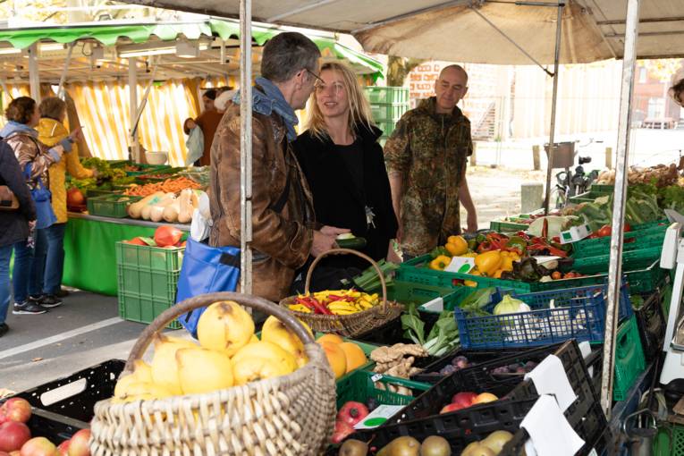Kundschaft an einem Obst- und Gemüsestand.