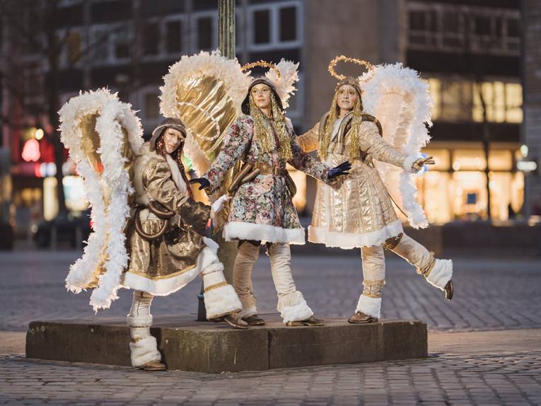 Drei als Engel verkleidete Menschen