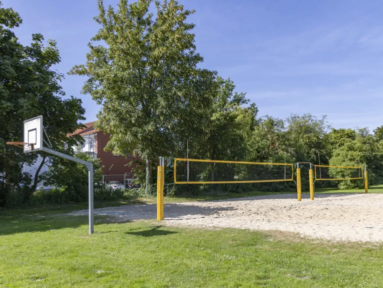 Grr&uuml;nfl&auml;che mit Basektballkorb und Beachvolleyballfeld