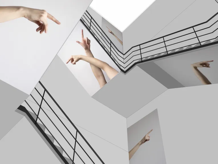 Staircase in which photographs of pointing arms and fingers are displayed