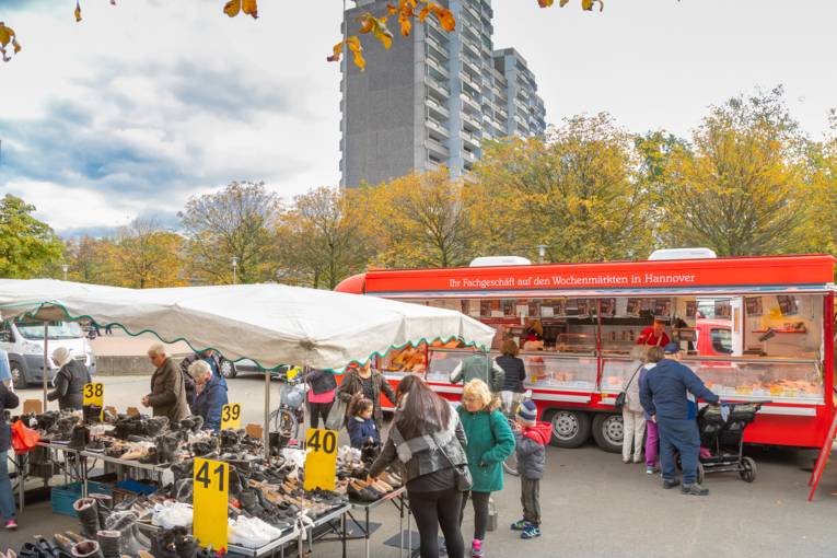Menschen an einem Schuhstand auf dem Wochenmarkt Sahlkamp.