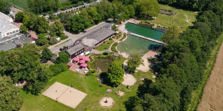 Luftbild eines Schwimmbades mit Spiel-, Sport- und Liegeflächen