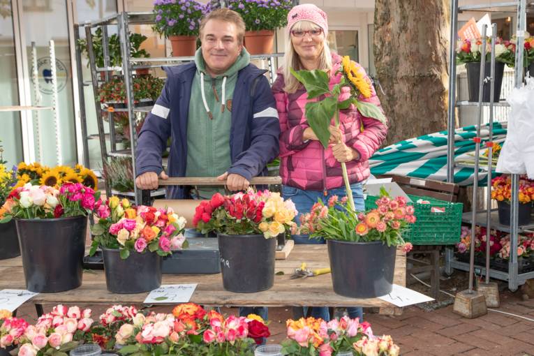 Ein Mann und eine Frau an einem Blumenstand.