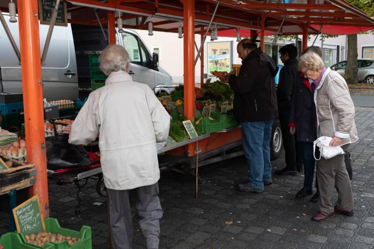 Kund*innen an einem Stand auf dem Wochenmarkt Rübezahlplatz