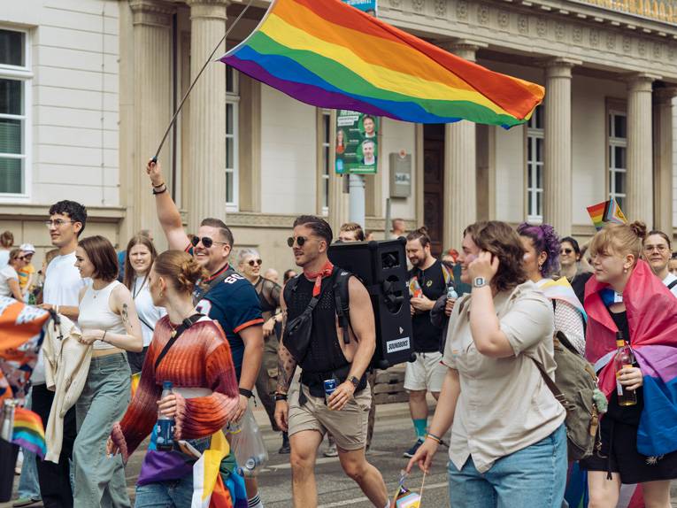 Menschen demonstrieren mit Regenbogenflaggen für Gleichberechtigung