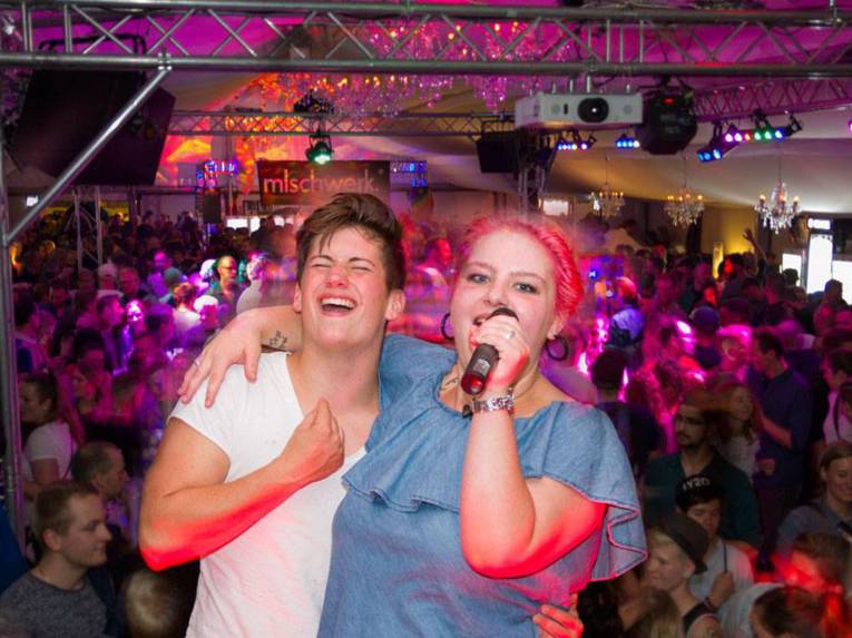 Eine Collage, die zwei Motive einer Person zeigt. Einmal steht sie auf einer Bühne, das andere zeigt eine artistische Einlage.