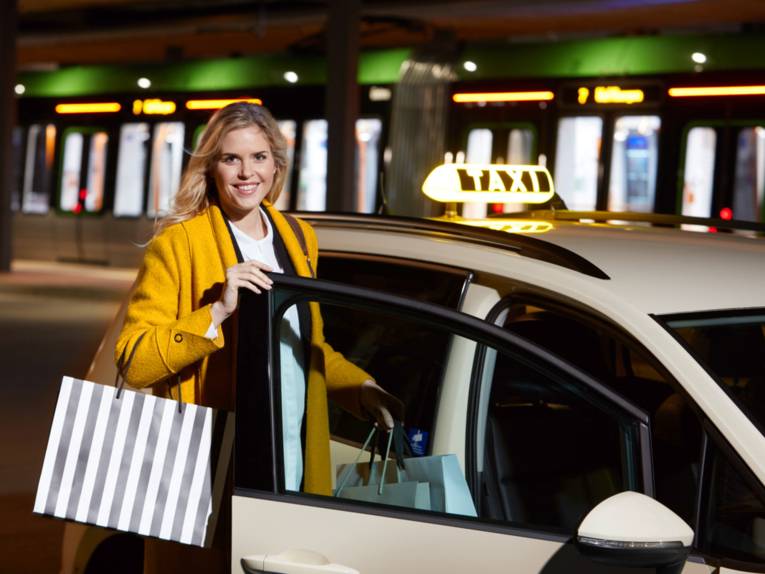 Eine Frau an einem Taxi.