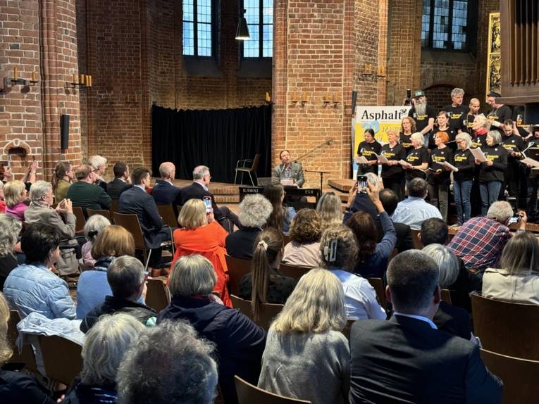 Ein Chor singt in der Marktkirche vor den gut gefüllten Besucherbänken.