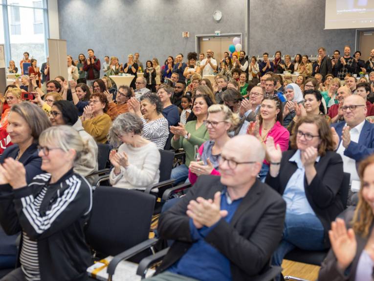Applaudierendes Publikum in einem Saal.