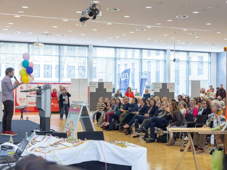 Ein Mann auf einer Bühne vor Publikum.