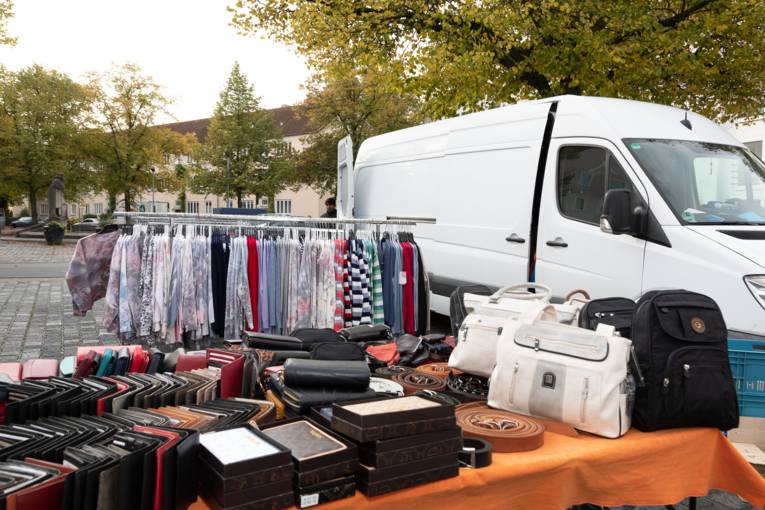 Ein Marktstand, auf dem Portemonnaies, Gürtel, Taschen und ähnliches angeboten werden.