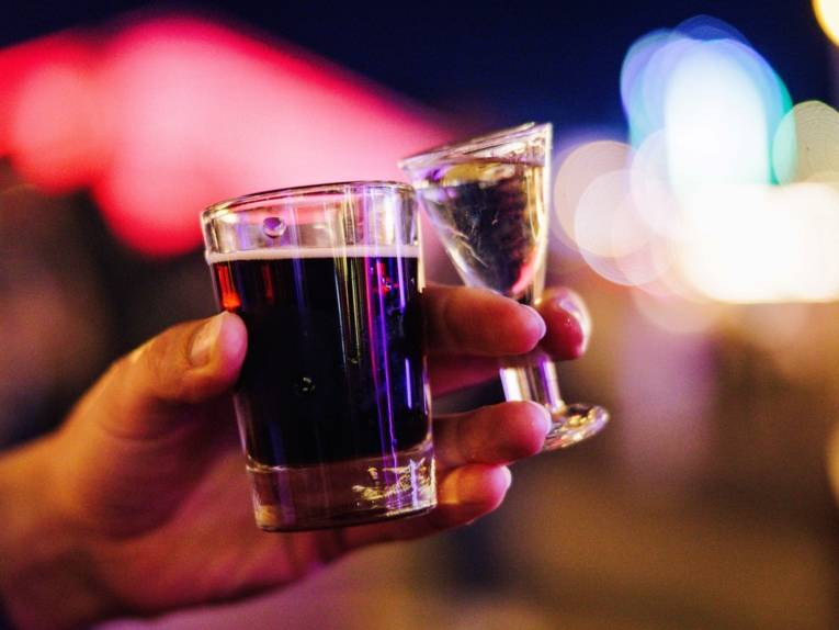 Eine Hand mit zwei Gläsern.