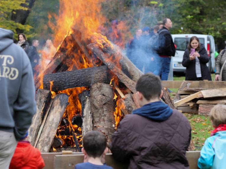 Menschen beim Tiergartenfest. Sie beobachten ein Lagerfeuer.