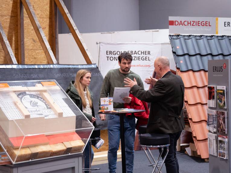 Beratungsgespräch an einem Messestand für Dachziegel.