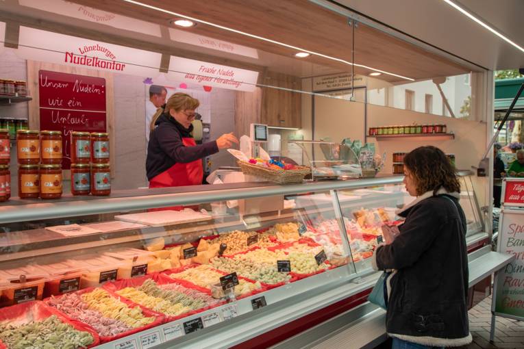 Eine Kundin kauft frische Nudeln.
