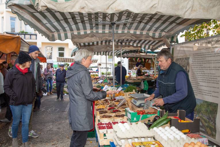 Ein Käufer zahlt seine Waren an einem Obst- / Gemüsestand.